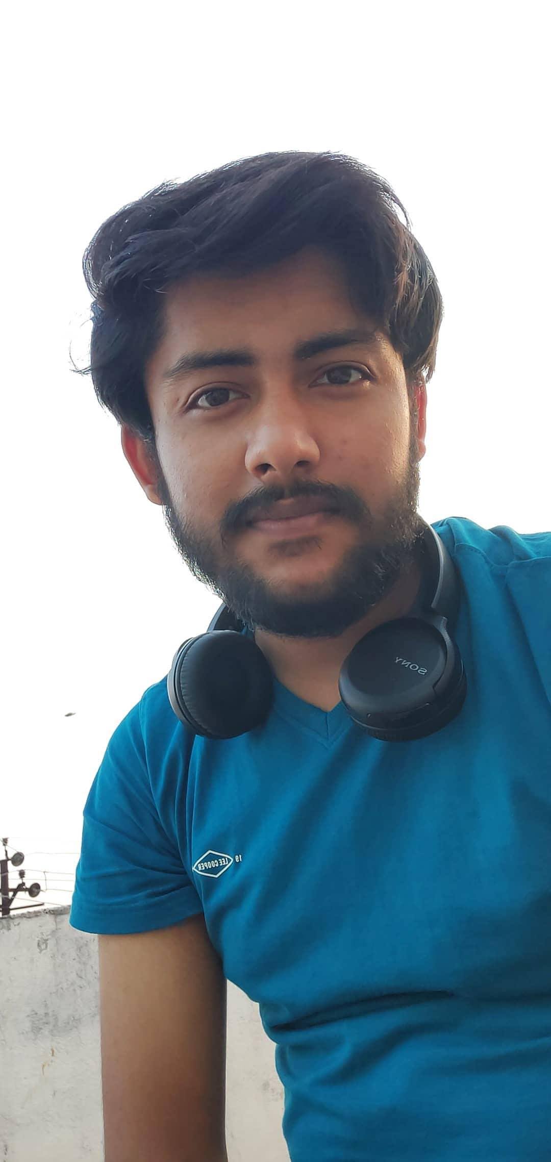 Vinayak with a pair of headphones around the neck
